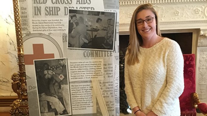 Students stands with exhibit panel