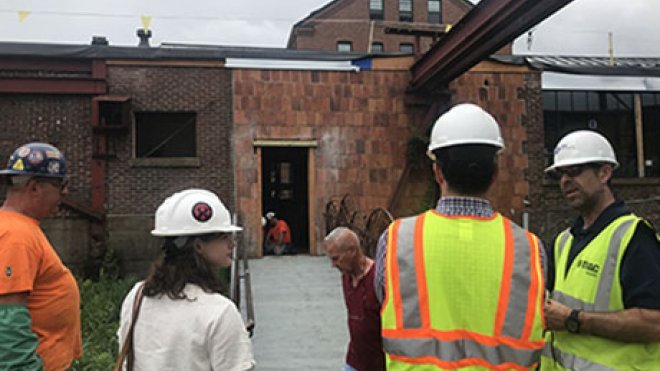 People in hard hats work on the Super Studio