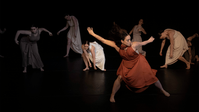 Seven dancers on stage performing