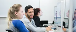 students work on computers and smile