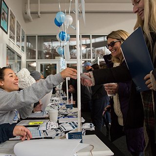 image of student welcoming visitors during Open House