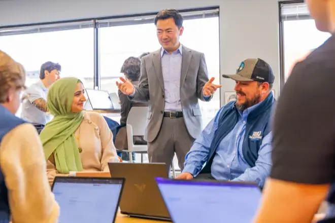 MBA students complete group work with professor