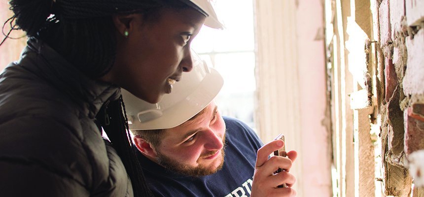 image of two RWU Engineering students in hardhats looking at work in progress at Fort Adams State Park in Newport, R.I.