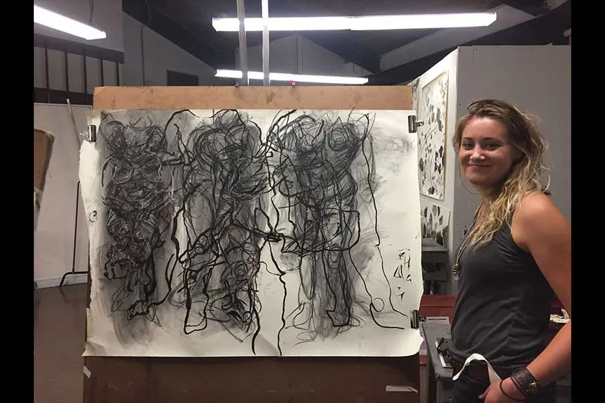 A student standing next to her work.