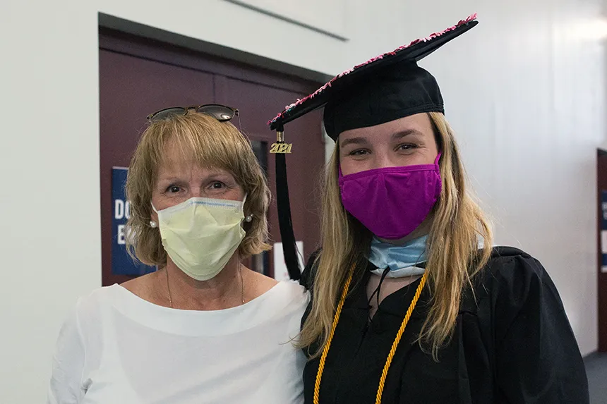 Image of a 2020 graduate posing with a family member