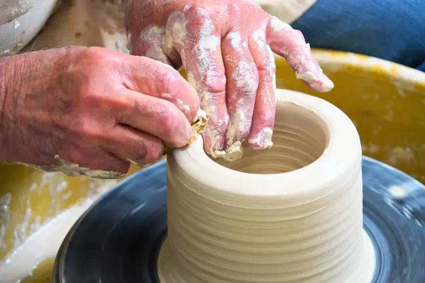 Denis Leonti molds clay at the wheel.