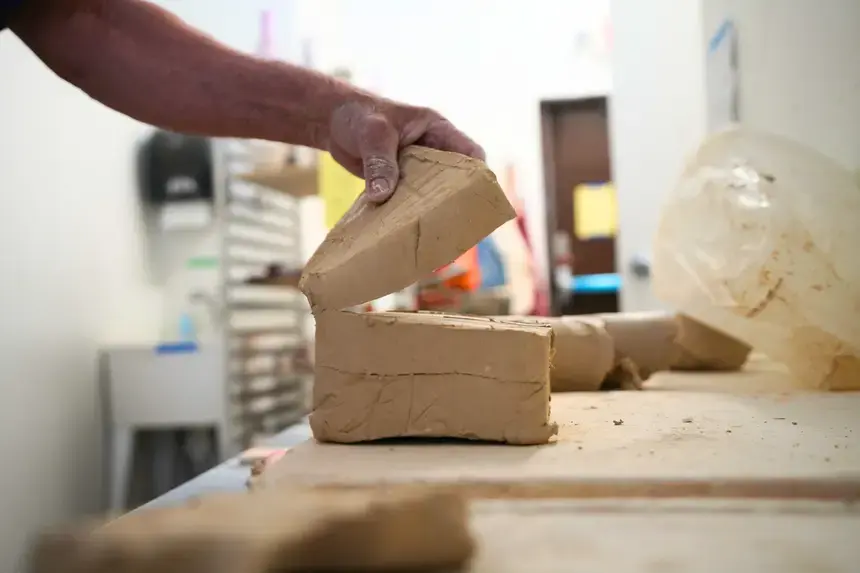 Denis Leonti picks up a slab of clay.