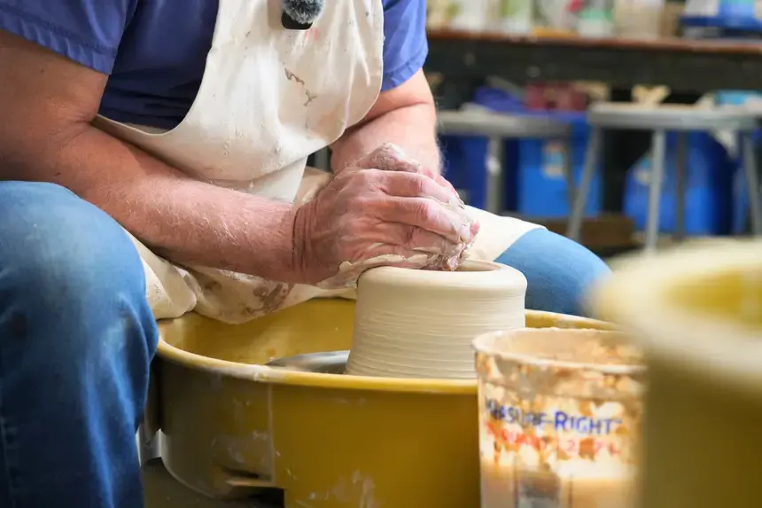 Denis Leonti molds clay at the wheel.