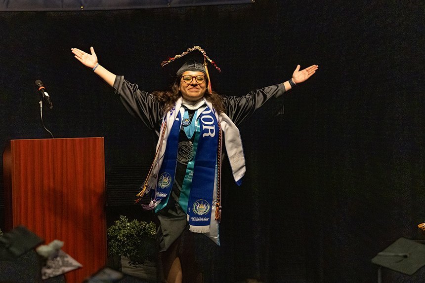 A graduate celebrates on stage