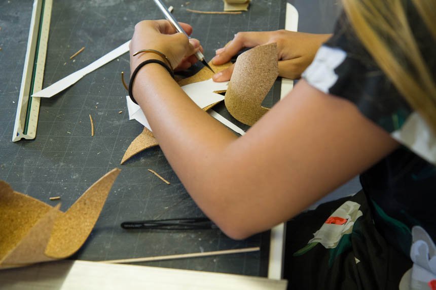 Gabby P. using knife to cut cork.