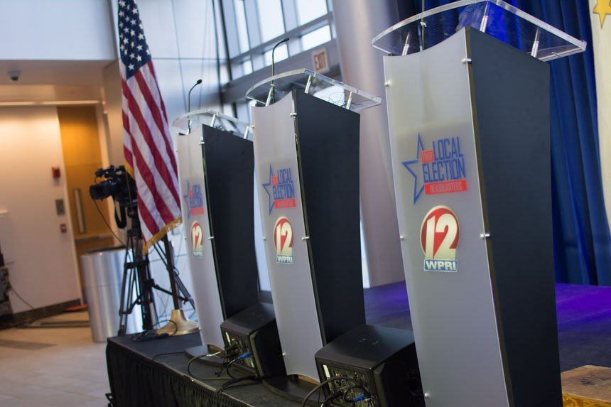 Three Channel 12 podiums with an American Flag. 