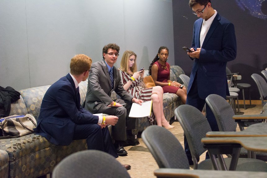 Students chat and look at their phones. 