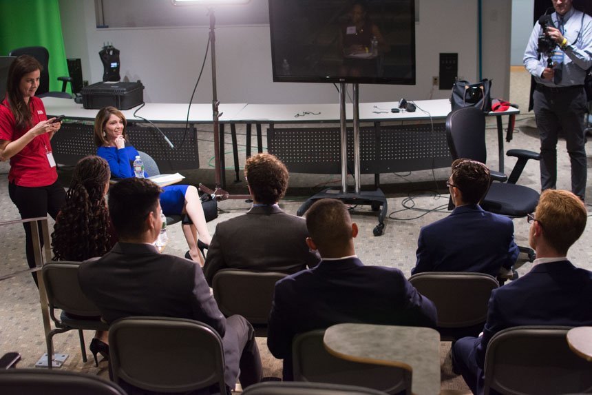 News anchor speaks to a group of students.