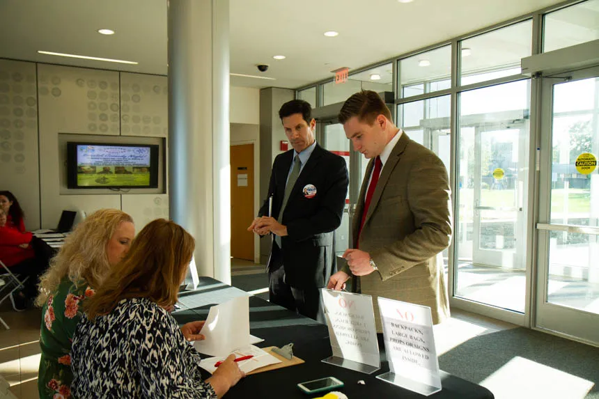 Two people check in at table. 