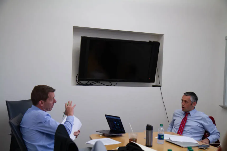 Two people sit at a table and talk.