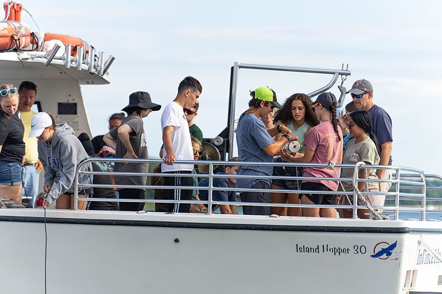 Students handling a water collection device on the InVinceble Spirit. 