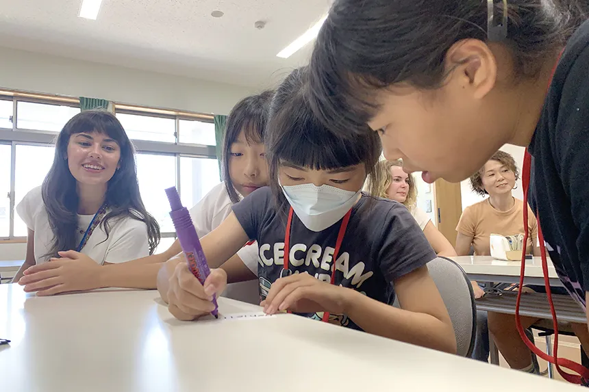 An RWU student looks on as students work in a classroom during a study abroad trip to Japan.