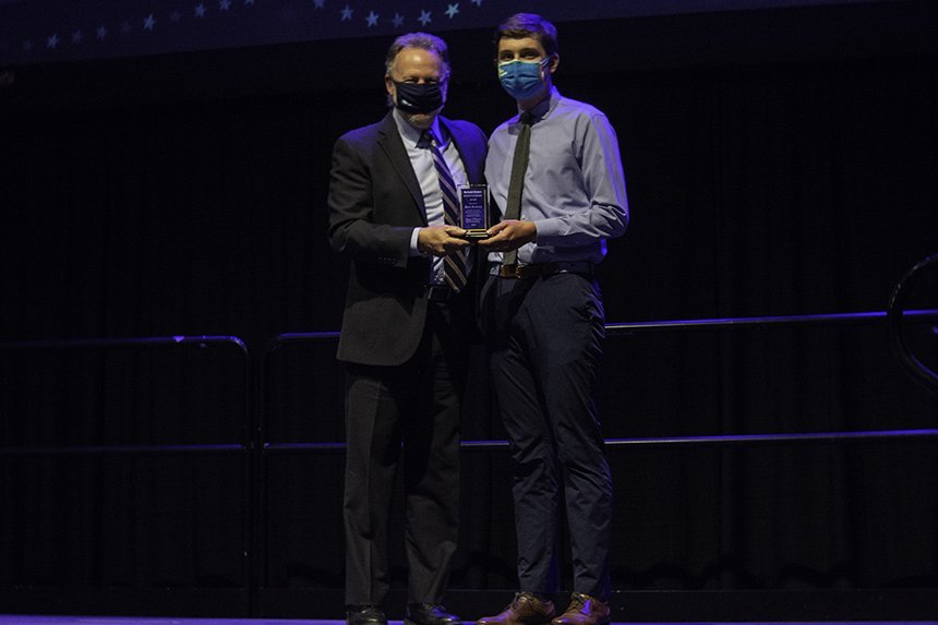 Student poses with award 