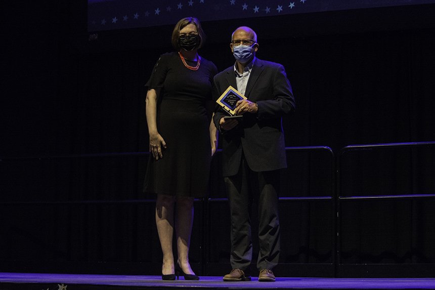 Professor poses with award 