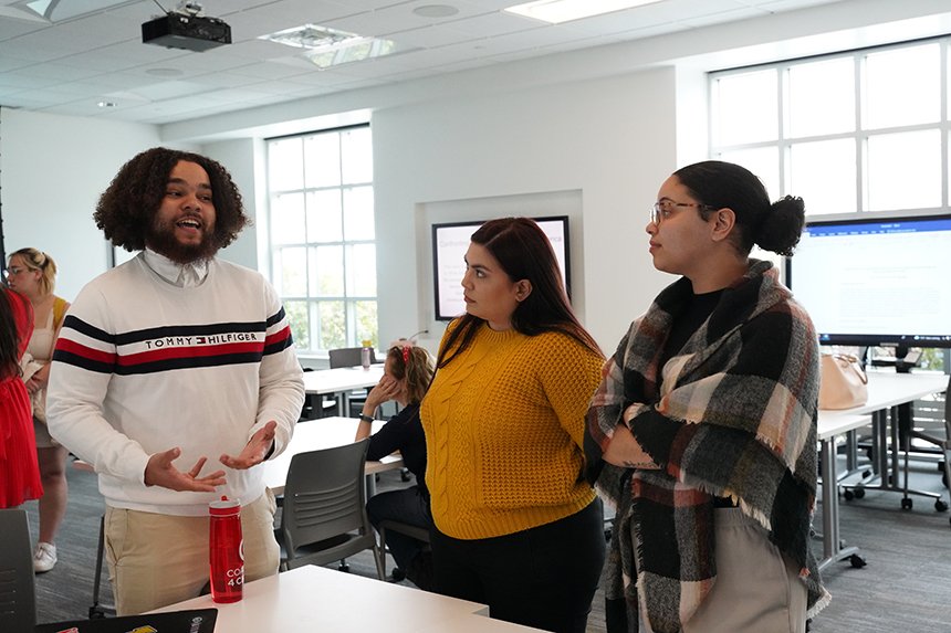 A student talking about his SASH project to two staff members 