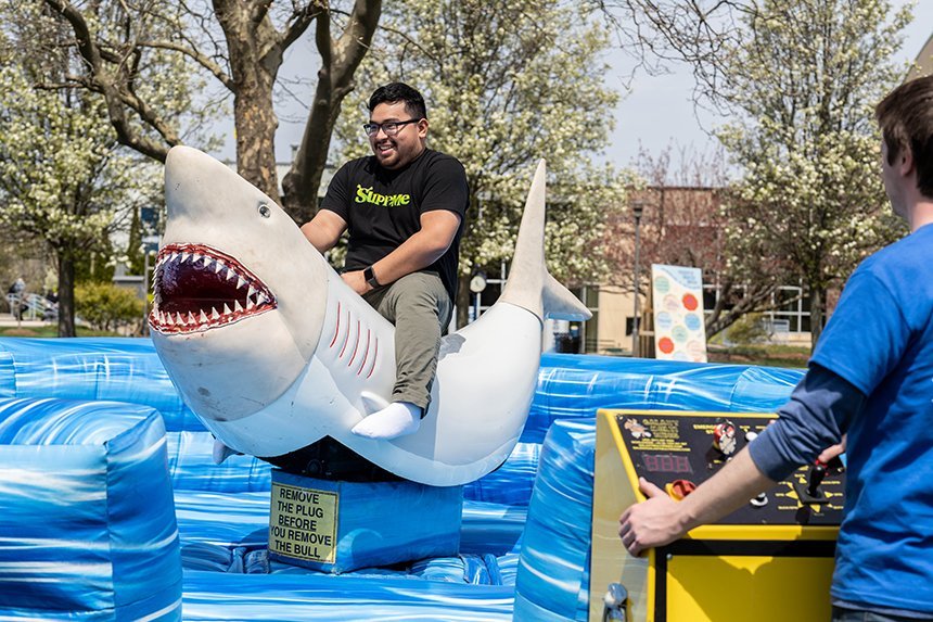 A student riding the mechanical shark ride. 