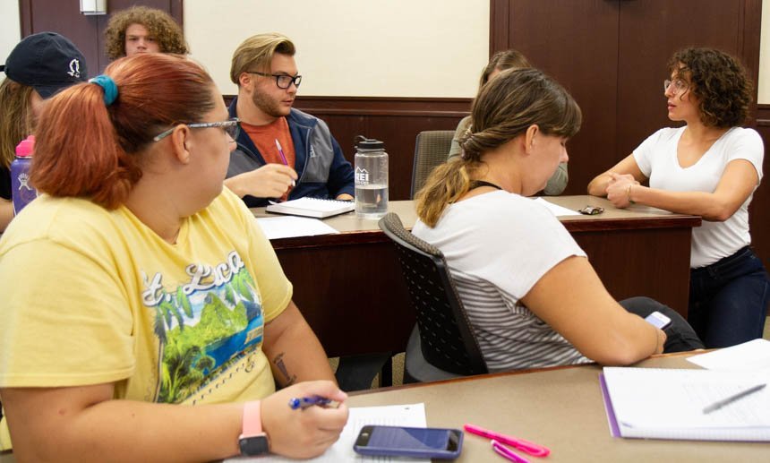 Presentation facilitator speaks with group of students. 