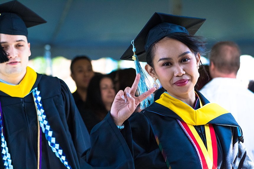 image of member of RWU Class of 2019 flashing a 'peace' sign