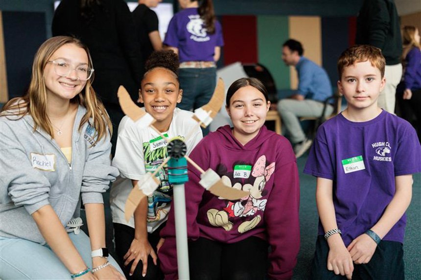 Students at KidWind pose with their wind turbine