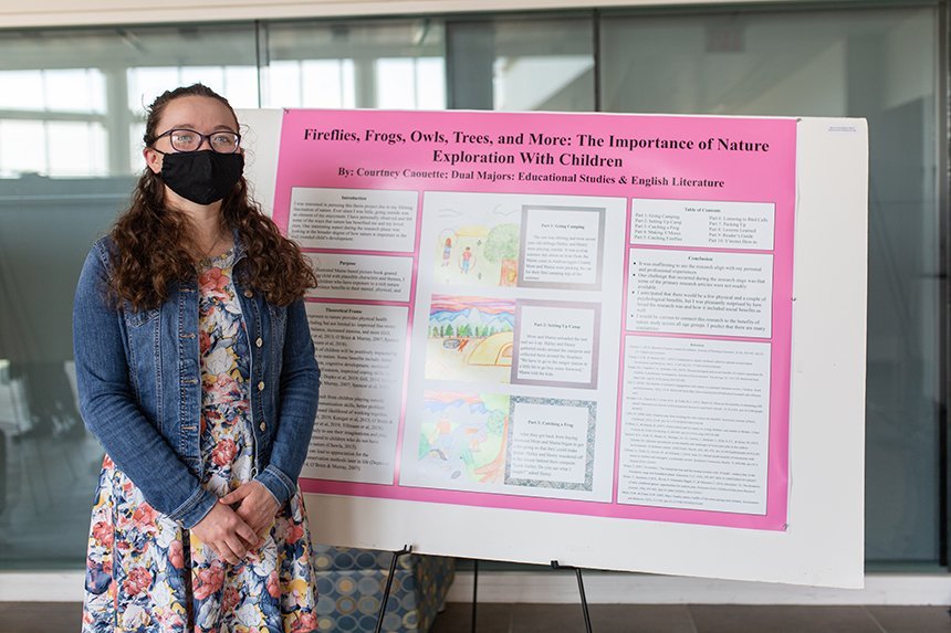 Student poses with poster