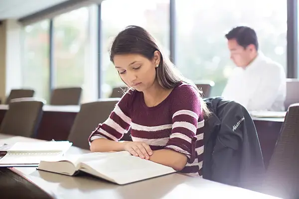 A student reading a book in a classroom